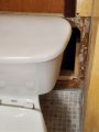 Open hole behind toilet